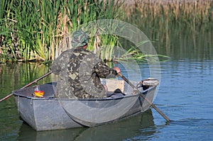 Fisherman rowing on a metal boat