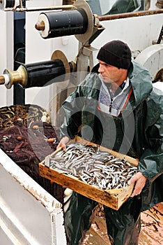 Fisherman carrying box with fish