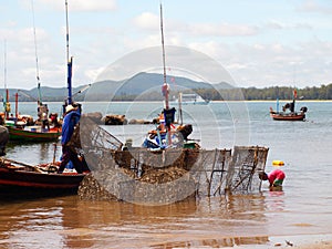 Fisherman carrys net in his boat