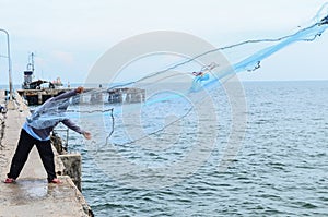 A fisherman casting his net from the boat