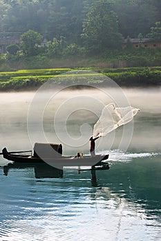 Fisherman casting net on river