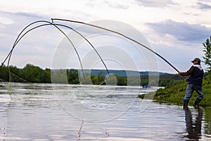 A fisherman catch fish on a crochet net on the Dniester River.