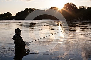 Fisherman catches of salmon at sunset