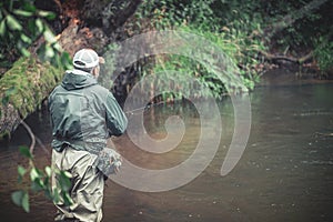 A fisherman catches spinning in the waders. Trout fishing