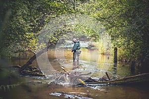 A fisherman catches spinning in the waders. Trout fishing photo
