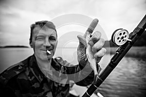 Fisherman catching fish on the lake. Black and white photography.
