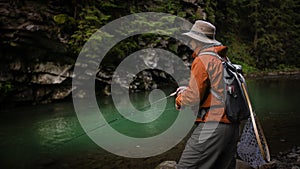 Fisherman catching trout on a river.