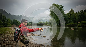 Fisherman catching trout on a river.