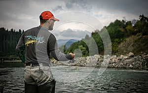 Fisherman catching trout on a river.