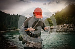 Fisherman catching trout on a river.