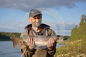 Fisherman caught a big salmon.