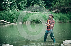 Fisherman caught a fish. Man pulling fishing rod. Man fishing on river.