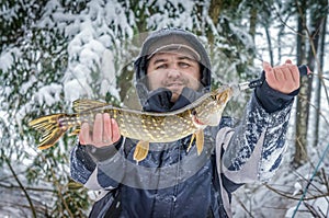 A fisherman caught a pike on winter fishing