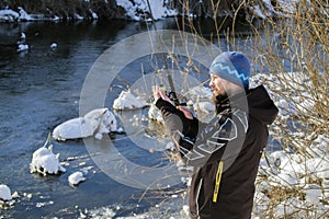 Fisherman checking bait. Open water fishing in winter. Spinning fishing in winter