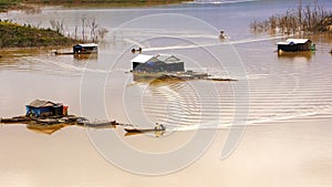 Fisherman coming their lake dwelling by motor-boat at fishing vi