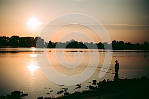 Fisherman at dawn fishing on a fishing rod