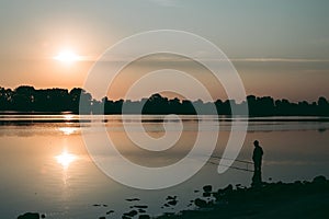 Fisherman at dawn fishing on a fishing rod