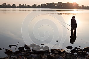 Fisherman at dawn fishing on a fishing rod