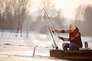 Fisherman draws hooked fish from water