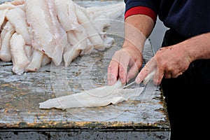 Fisherman filleting cod