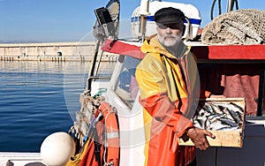 A fisherman with a fish box inside a fishing boat