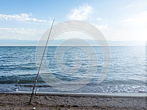 .Fisherman fishes early in the morning on the shore. Fishing rod and spinning. Camping.