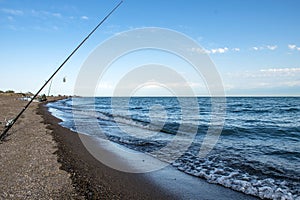 .Fisherman fishes early in the morning on the shore. Fishing rod and spinning. Camping