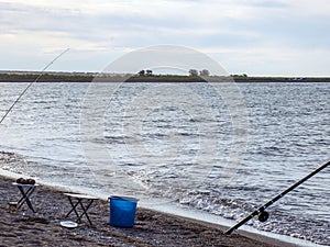 .Fisherman fishes early in the morning on the shore. Fishing rod and spinning. Camping