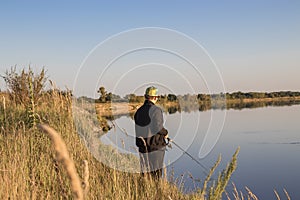 Fisherman fishes spinning on the river bank