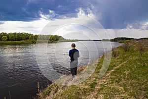 Fisherman fishes spinning on the river bank