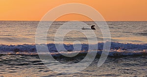 Fisherman with fishing boat and golden sunrise over the sea water