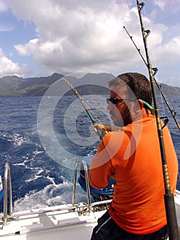 Fisherman fishing on boat in ocean on Seychelles