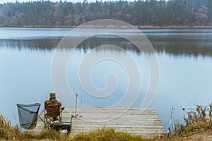 fisherman fishing at calm autumn lake