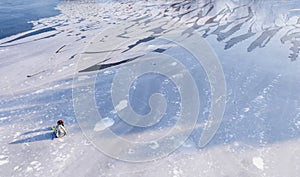 Fisherman is fishing on a frozen lake, view from a drone. Winter fishing with equipment