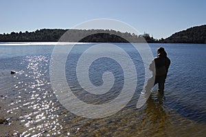 Fisherman fishing on a lake photo