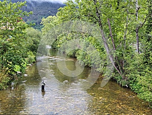 A fisherman fishing in the PiloÃ±a river in Infiesto, Asturias, Spain photo