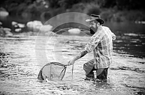 Fisherman fishing on a rever. Relaxed fisher man with a fishing rod on a summer day.