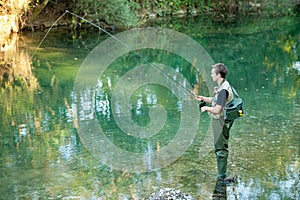 A fisherman fishing on a river