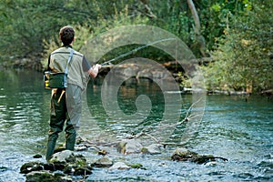 A fisherman fishing on a river