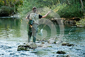 A fisherman fishing on a river