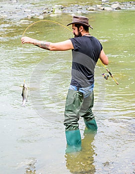 Fisherman with fishing rod. mature man fly fishing. man catching fish. bearded fisher in water. summer weekend. Big game
