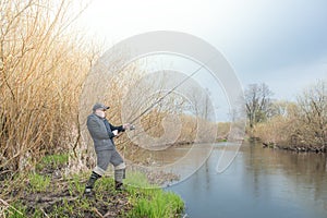 Fisherman with a fishing rod on the river bank