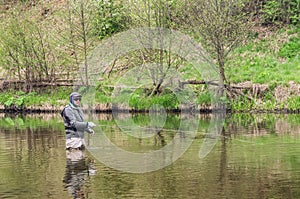 Fisherman fishing on a small spring river. Fly fishing