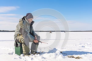 Fisherman fishing winter fishing on a bright Sunny day