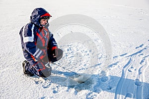 A fisherman is fishing with a winter spinning rod on a frozen lake