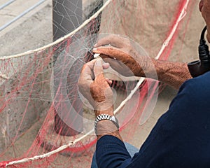 Fisherman is fixing a fishing net