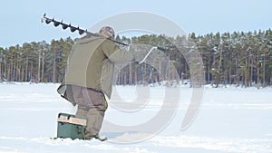 Fisherman on a frozen lake ice fishing