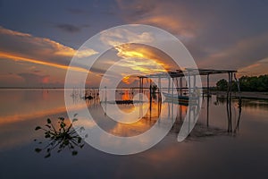 Pescador sobre el un barco durante amanecer sobre el 