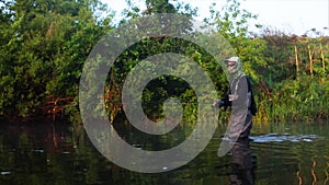 Fisherman goes fly fishing in the morning river