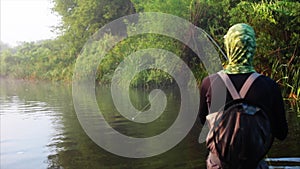 Fisherman goes fly fishing in the morning river